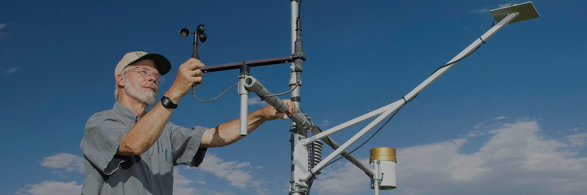 Agricultural engineer checking the sensors on a field weather station